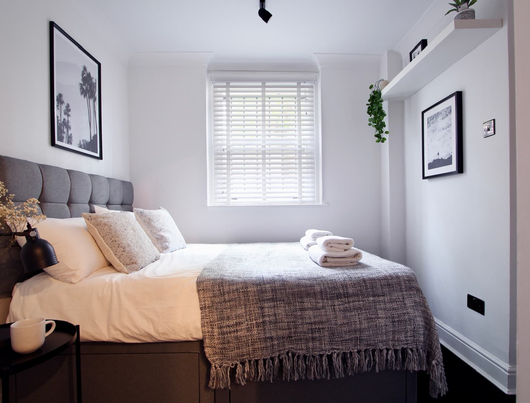 The main bedroom — upholstered headboard, crisp white bedding and fresh towels