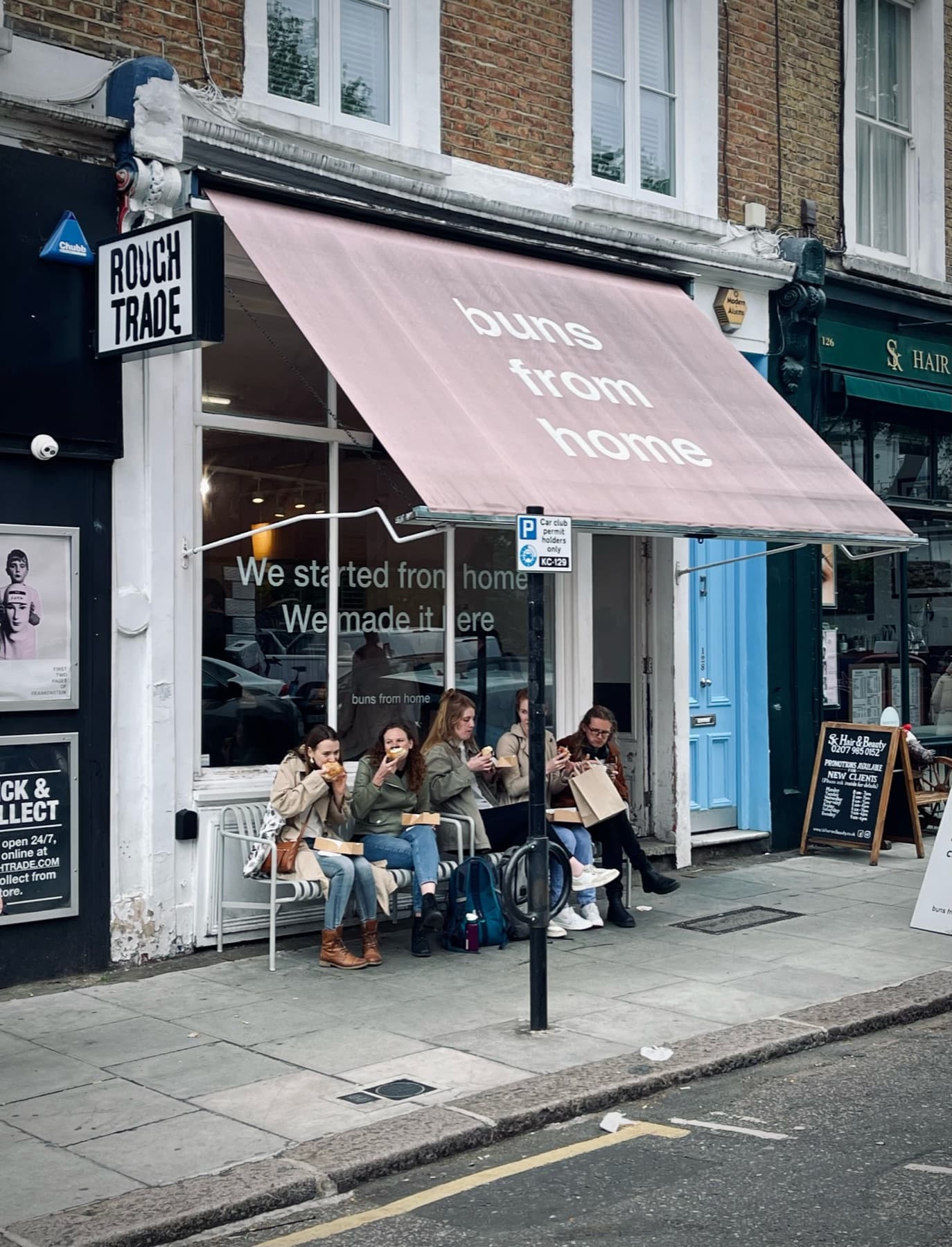 A pastel café terrace on a Notting Hill street near the flat